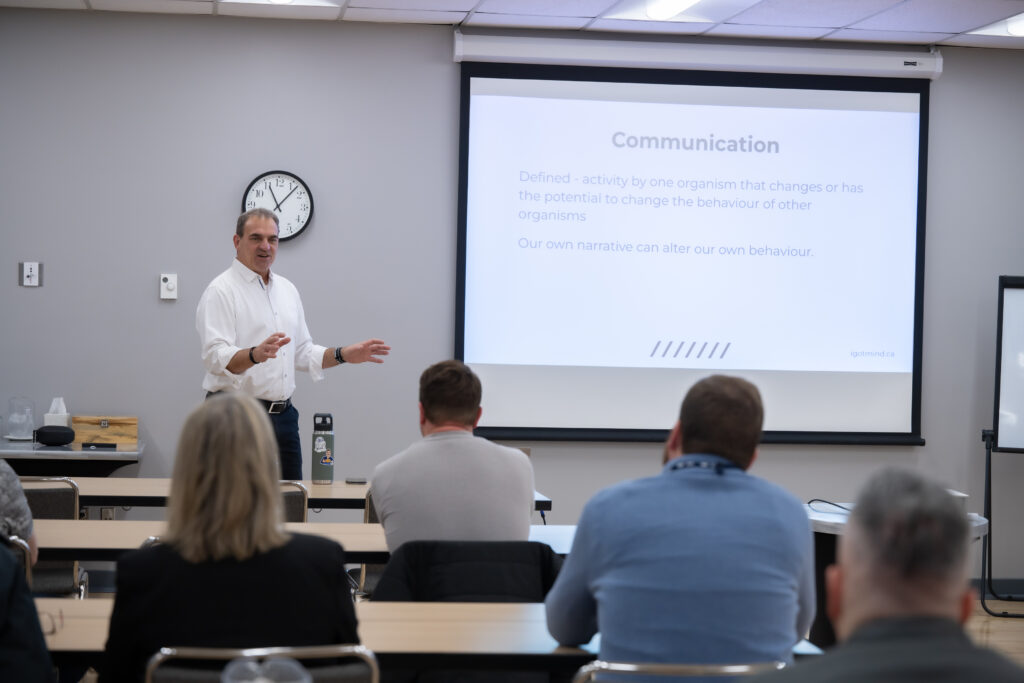 Image of man speaking to a classroom of people